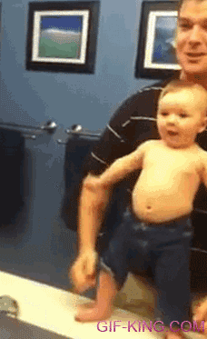 cute baby adorably flexing muscles with dad